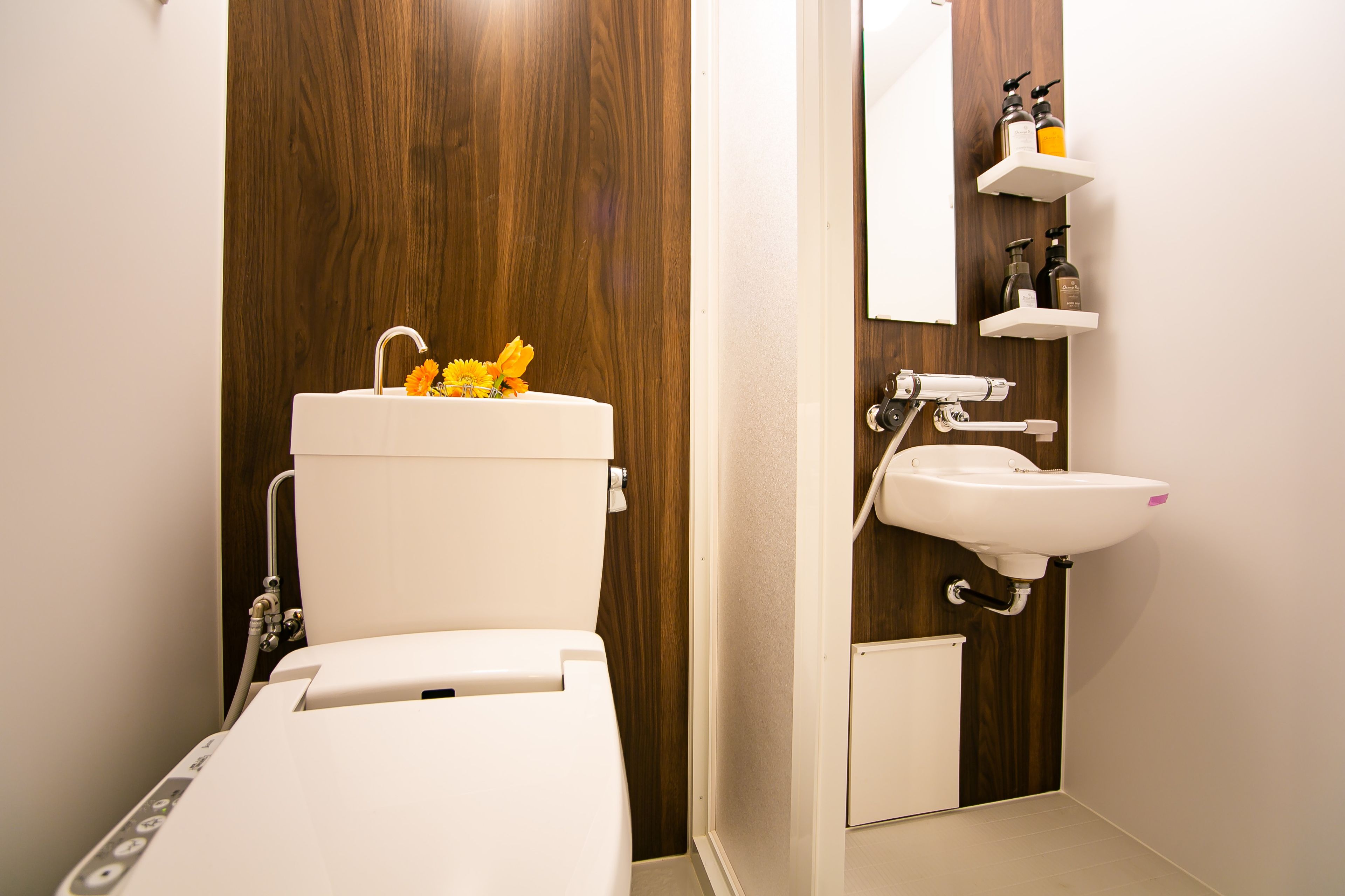 A modern bathroom with a toilet, sink, and wooden paneling.