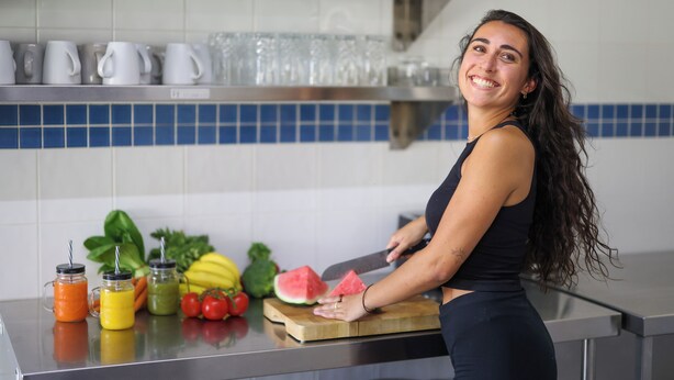 A kitchen counter with a cutting board, a knife, and various fruits and vegetables. - Motel Sunshine Coast (Caloundra)