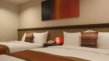 Une chambre d’hôtel avec deux lits, une table de chevet avec un téléphone et une lampe rouge, et un grand tableau abstrait accroché au mur.