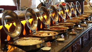 Un buffet comportant plusieurs présentoirs, chacun étant surmonté d’un couvercle en métal et contenant une variété de plats.