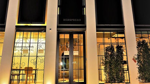 A building with arched windows and a sign reading "BEDSPRING." - Bedspread Hostel - Adults Only (Bangkok)