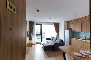 A modern apartment with a living area, kitchen, and balcony. - NYT Home Cau Giay (Hanoi)