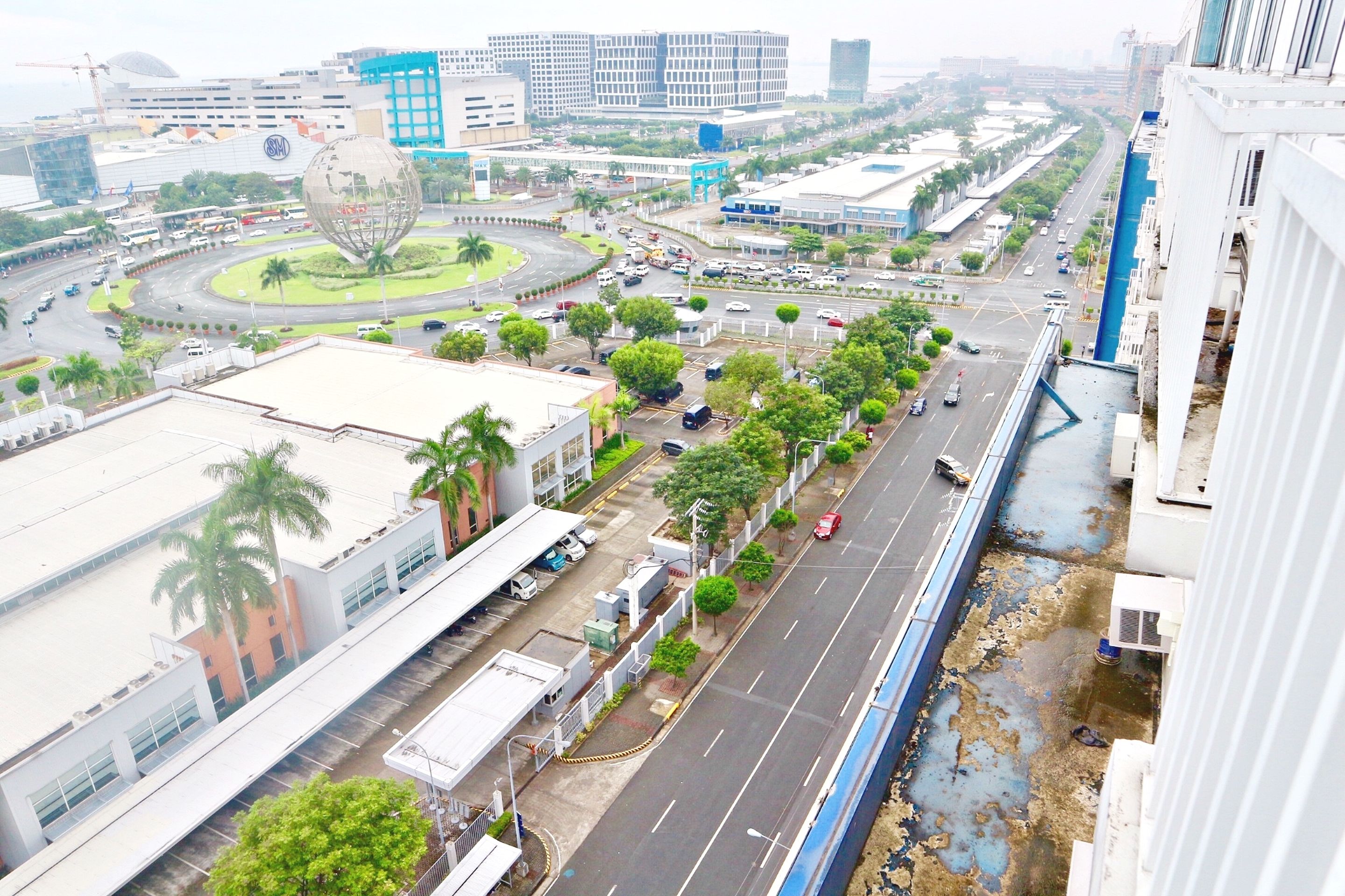 A cityscape with a roundabout, buildings, and a blue bridge.