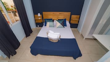 Relax in this serene space with a large bed, bedside tables, and a wicker basket for your essentials.