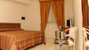 A hotel room with a bed, a chair, a coffee machine, and curtains. - Le Dodici Lune (Montecorvino Rovella)