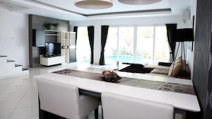 Una cocina moderna con comedor, televisor integrado y ventanas amplias.
