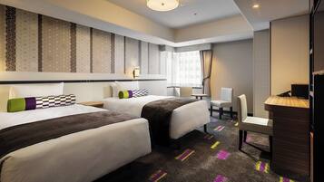 A hotel room with two beds, a desk, a chair, and a large window with curtains.