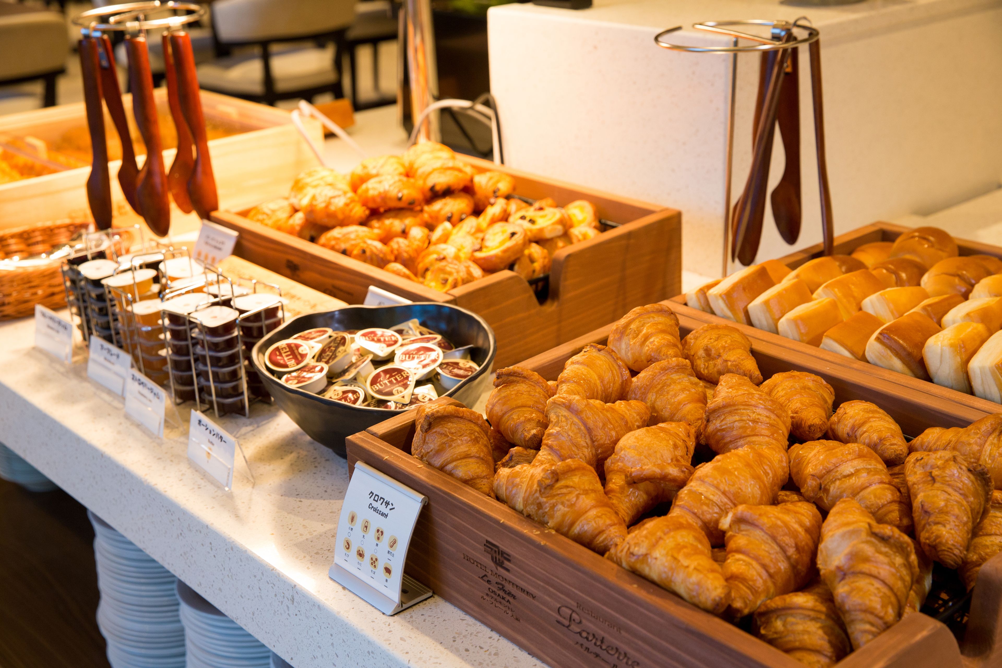 A buffet with various baked goods including croissants and pastries.