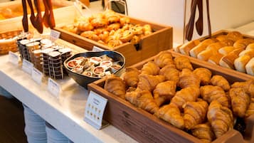 A buffet with various baked goods including croissants and pastries.