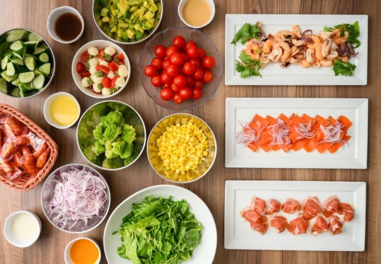 Diversos alimentos e ingredientes dispuestos sobre una mesa de madera.