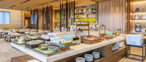 Montaje de bufé con diversos alimentos y una máquina de café.