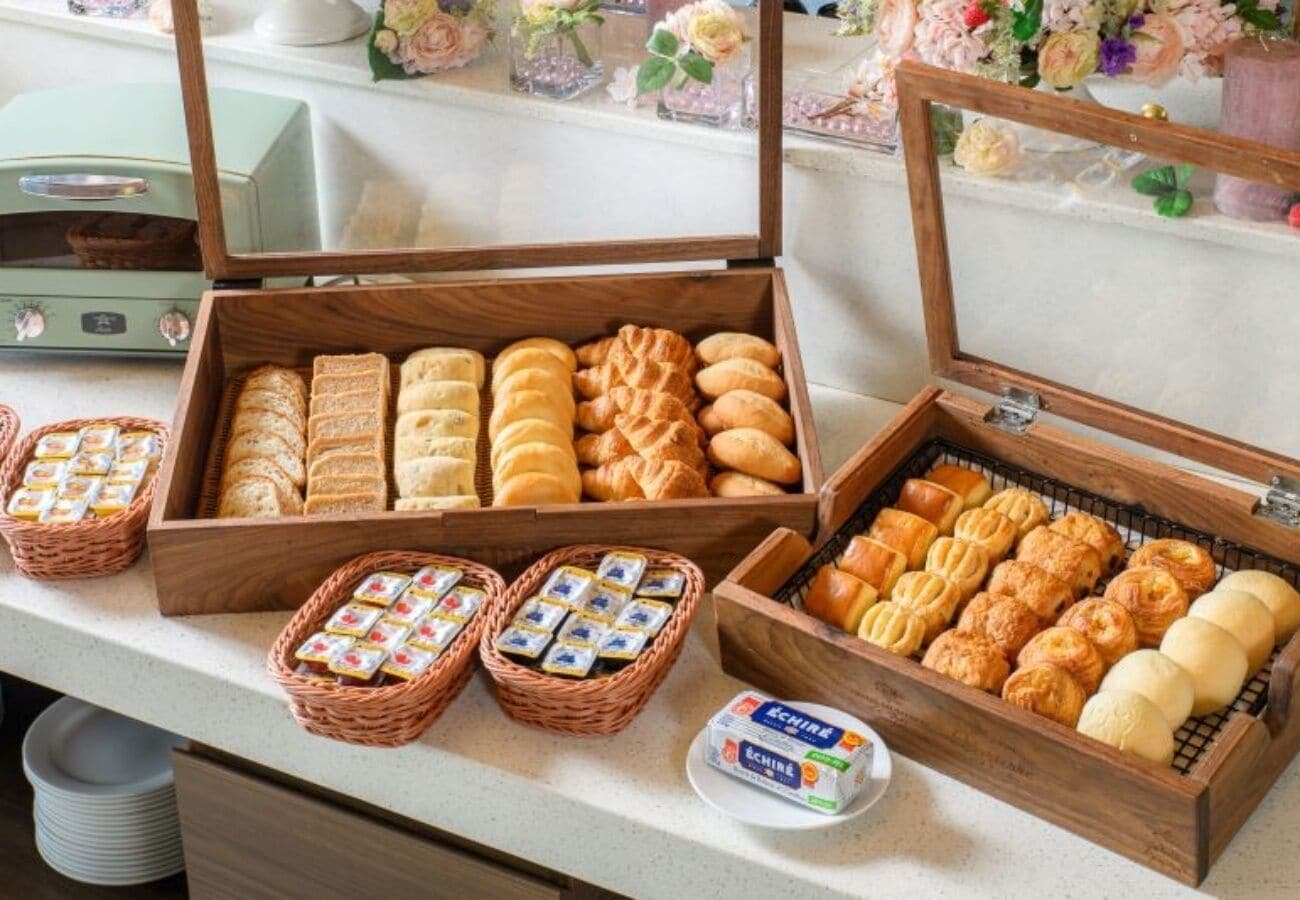 A buffet with various baked goods and a small container of butter.
