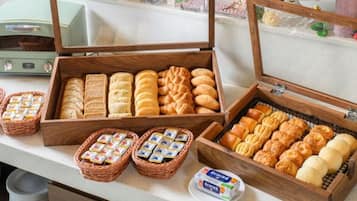 A buffet with various baked goods and a small container of butter.