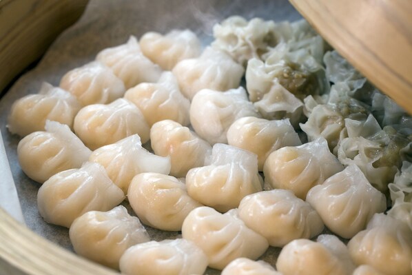 Primer plano de dumplings al vapor en una vaporera de bambú.