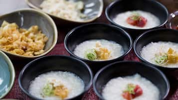 Des bols de porridge de riz, garnis de divers accompagnements, sont disposés sur une table.