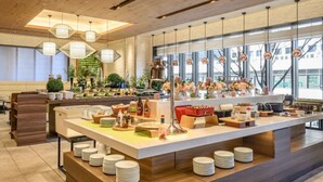 Una cocina moderna con una isla central, diversos alimentos y un amplio ventanal que proporciona luz natural.