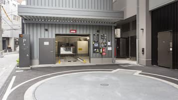 Ein Gebäudeeingang mit Parkschild, Brandmelder und Gegensprechanlage.