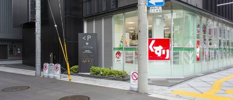 Un edificio con fachada de vidrio, un cartel de no estacionamiento y una señal de orientación.