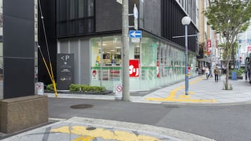 A modern building with a glass storefront, a no parking sign, and a pedestrian crossing.