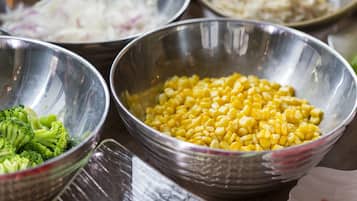 A table with several metal bowls containing different food items.