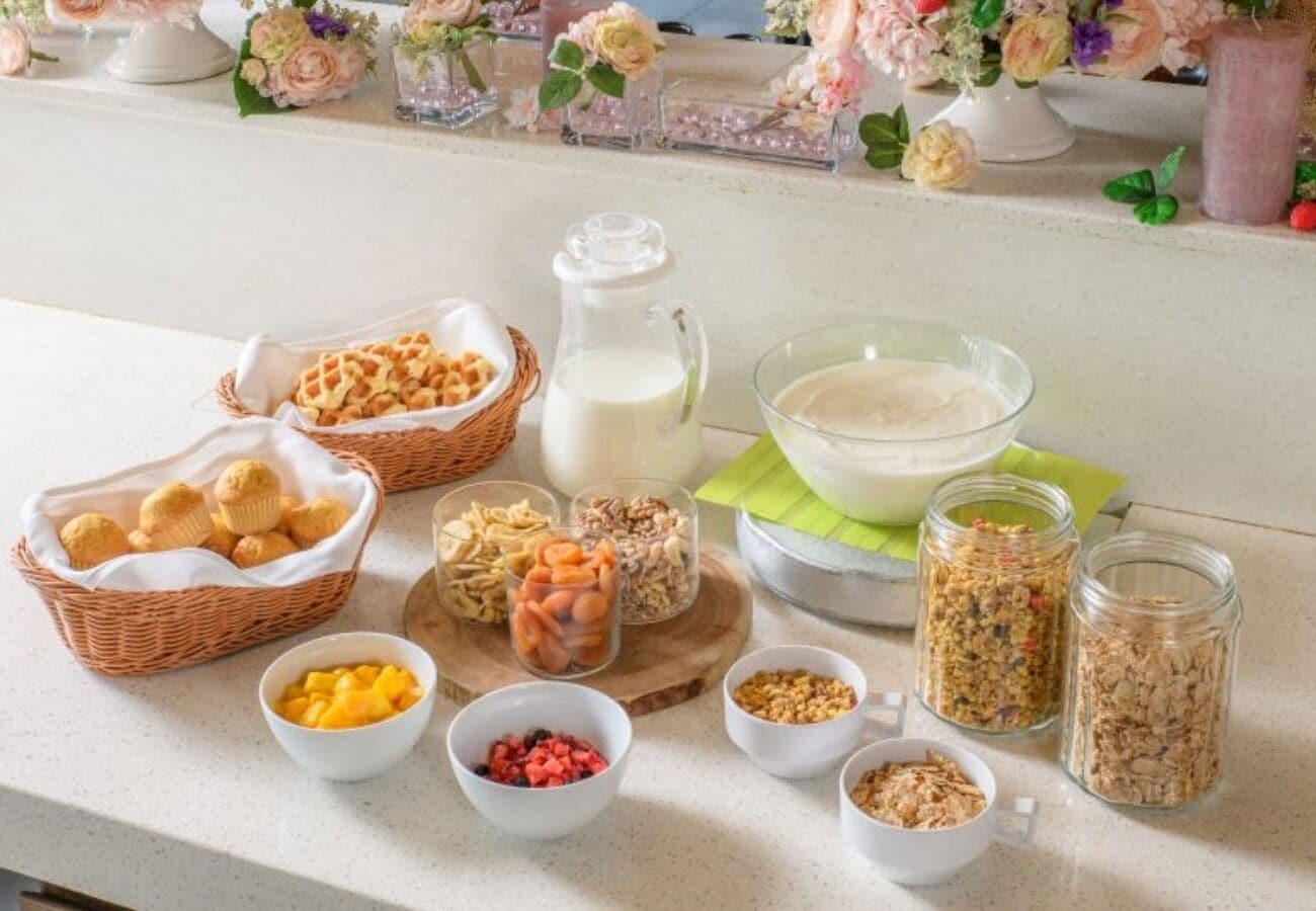 Un bufé de desayuno con diferentes alimentos y una jarra de leche.