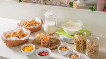 Un bufé de desayuno con diferentes alimentos y una jarra de leche.