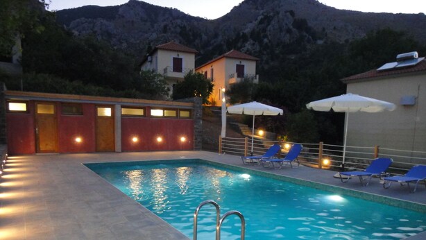 A swimming pool with a view of mountains in the background. - Victorias Rooms (Chios)