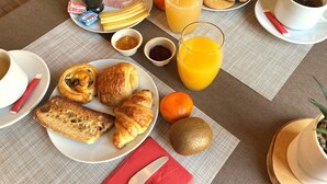 A breakfast setting with croissants, orange juice, toast, and a variety of spreads on a table. - Hôtel Le Saint Florent (Mont-pres-Chambord)