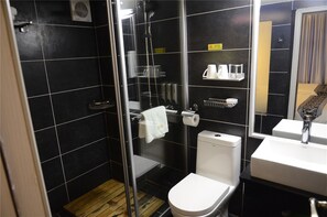 A modern bathroom with a glass-enclosed shower, a white toilet, and a sink with a mirror. - Humble Inn Boutique Residence (Guilin)