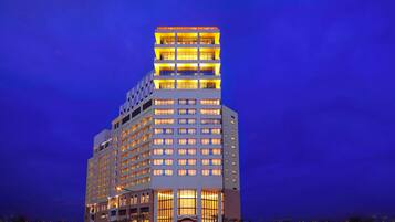 Um hotel com vários andares e design moderno, com entrada destacada e várias varandas.