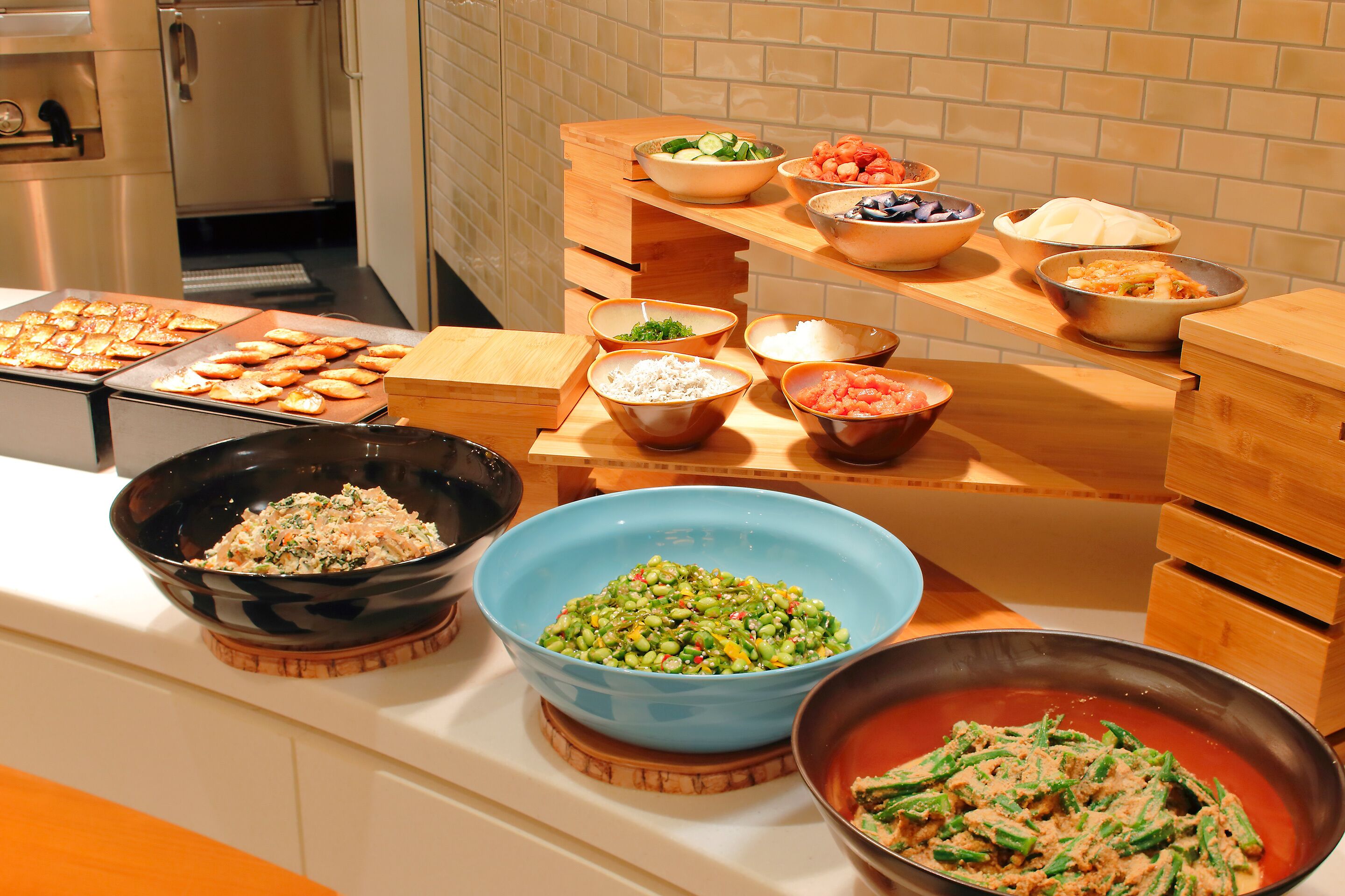 A buffet table with various dishes including salads, rice, and vegetables.