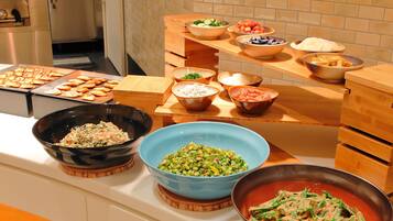 A buffet table with various dishes including salads, rice, and vegetables.