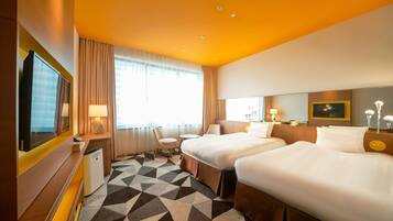 A hotel room with two beds, a desk, a chair, a TV, and a large window with curtains.