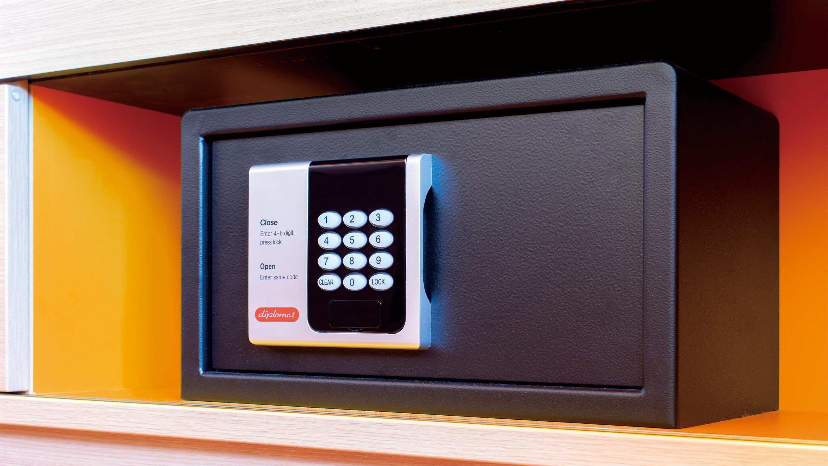 A secure electronic lock with a keypad, a close instruction label, and a diplomat brand logo.