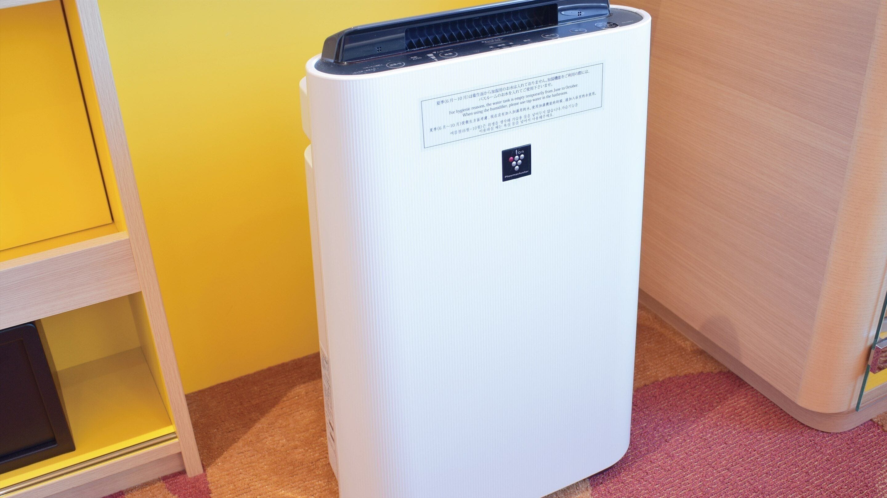 A white portable air conditioner with a control panel and a label with text in a foreign language.