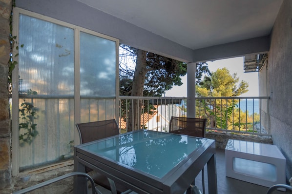 Enjoy the serene views of the surrounding landscape from this balcony with a glass-top table and two chairs.