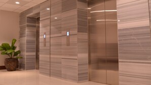 Een moderne lift met metalen wanden en een bedieningspaneel.