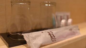 A hotel room with a minibar, a glass, and a tissue package.