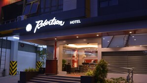 Het uiterlijk van Hotel Robertson, met een modern ontwerp, met een opvallende ingang, een receptiebalie en een trap die naar de lobby leidt.