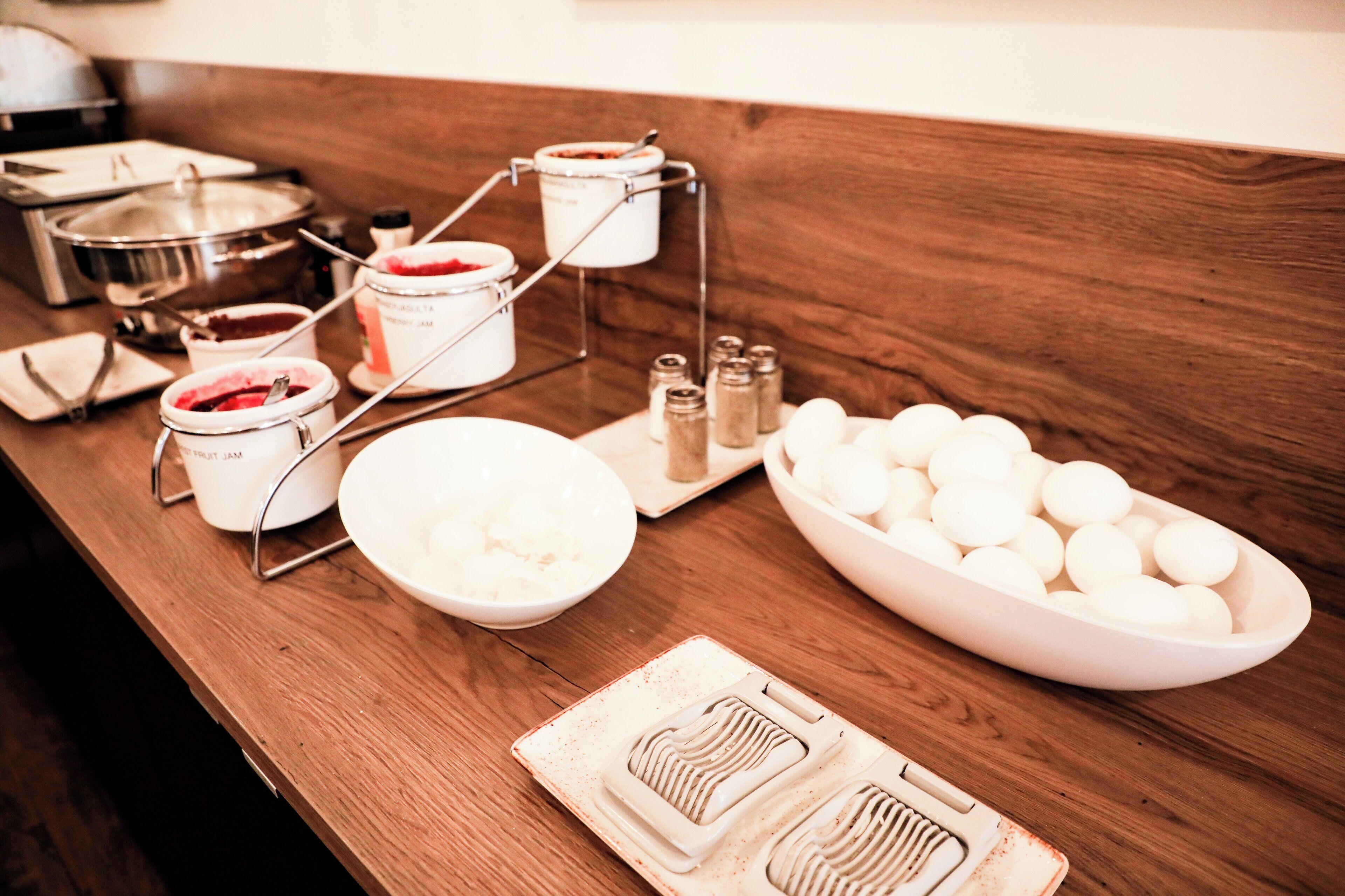 A buffet setup with various food items and condiments on a wooden table.