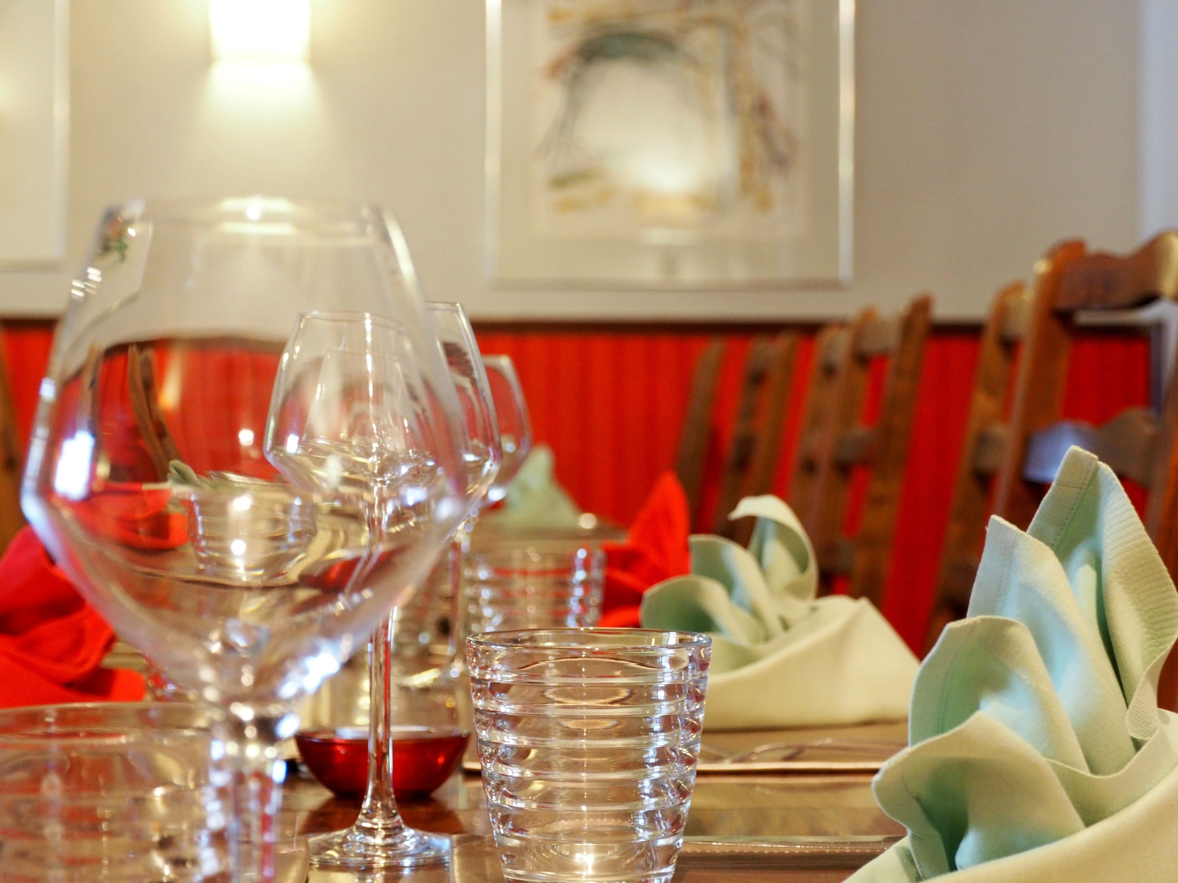 Une table à manger avec de la verrerie transparente, comprenant un verre à vin, un verre à eau et une carafe.