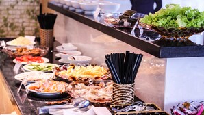 Un bufé con diversos alimentos y utensilios.