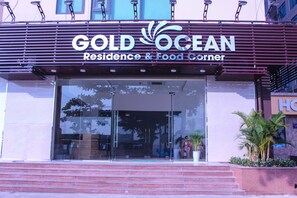The exterior of the GOLD OCEAN Residence & Food Corner, featuring a modern facade with large glass windows and a prominent entrance. - Gold Oceanus Nha Trang (Bac Nha Trang)