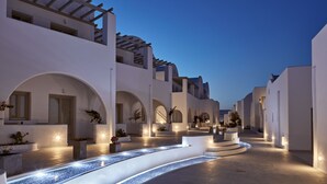 A modern building with white architecture, arched walkways, and a water feature.
