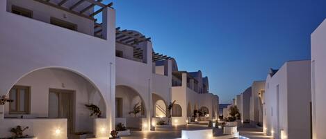 A modern building with white architecture, arched walkways, and a water feature.