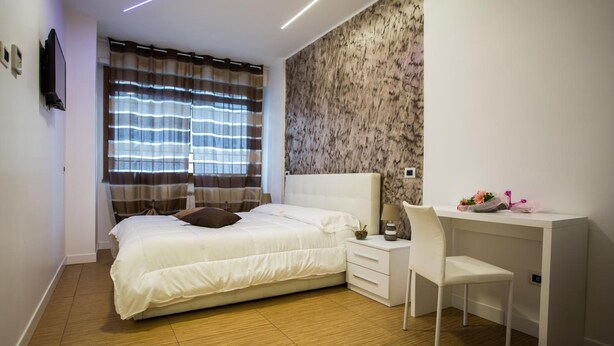 Quarto com cama, escrivaninha e cadeira.