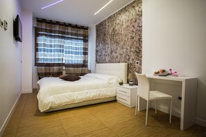 A bedroom with a bed, a desk, and a chair. - Valle Aurelia House (Rome)