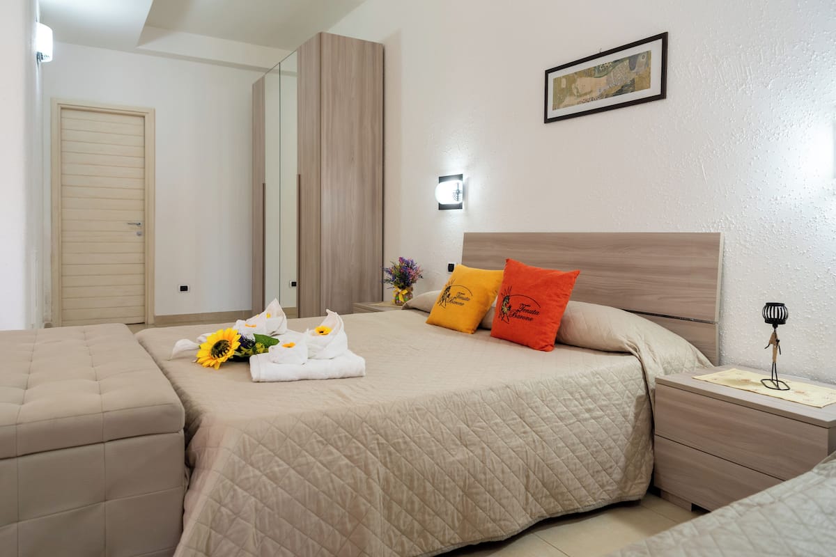 Une chambre d’hôtel avec un grand lit, une table de chevet avec une lampe et un miroir.