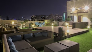 A rooftop terrace with outdoor seating, a pool table, and a bar area. - Tribecca Residency (Ahmedabad)