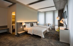 A hotel room with two beds, a desk, a chair, and a TV. - b smart motel Landquart (Landquart)